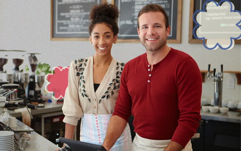 A woman and man stand behind a business counter waiting to welcome in their customers