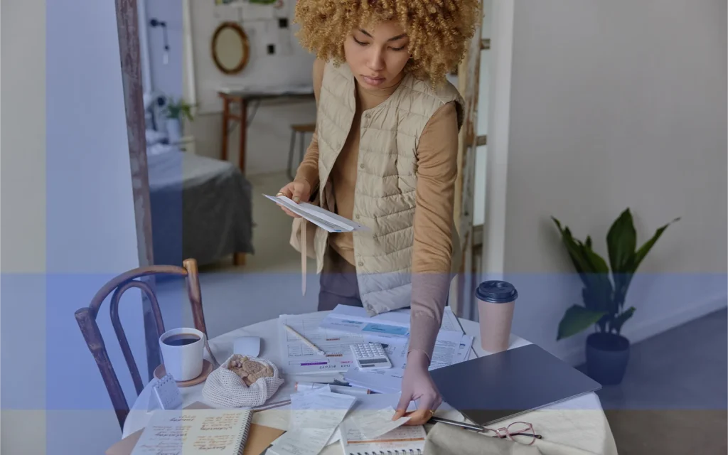 A person organizing files and paperwork on a table with a coffee