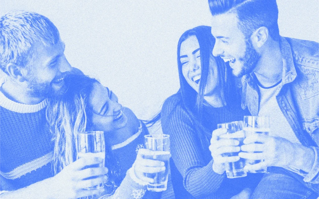Four friends smiling and enjoying drinks together