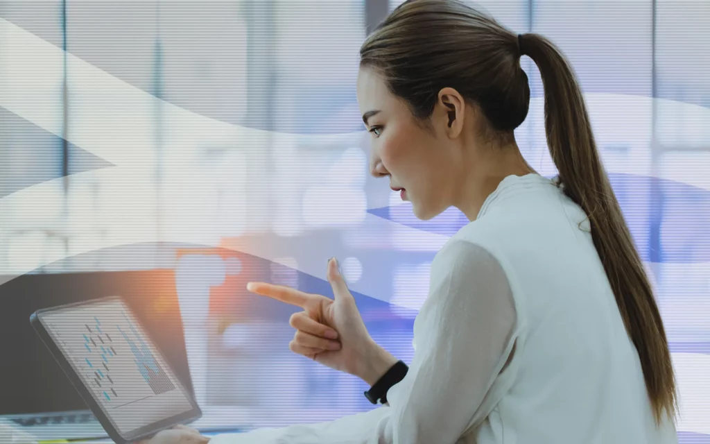 A young lady looks at a computer screen showing investment gains