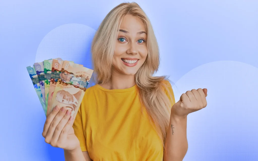 A smiling young person with blonde hair and a yellow shirt holds Canadian cash in one hand