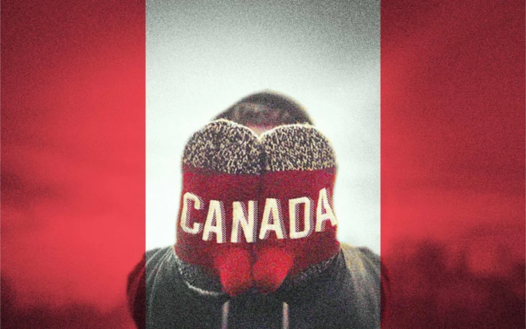 An image of a person holding up mittens that spell Canada