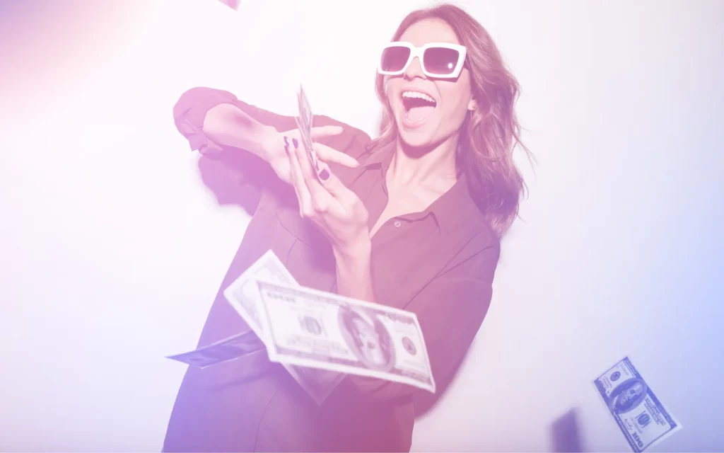 A young lady in sunglasses makes it rain with money