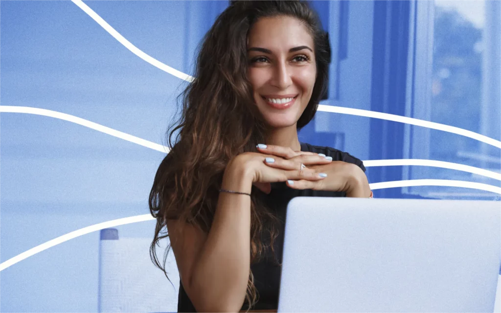 An edit of a young woman sitting in front of a laptop with a smile on her face