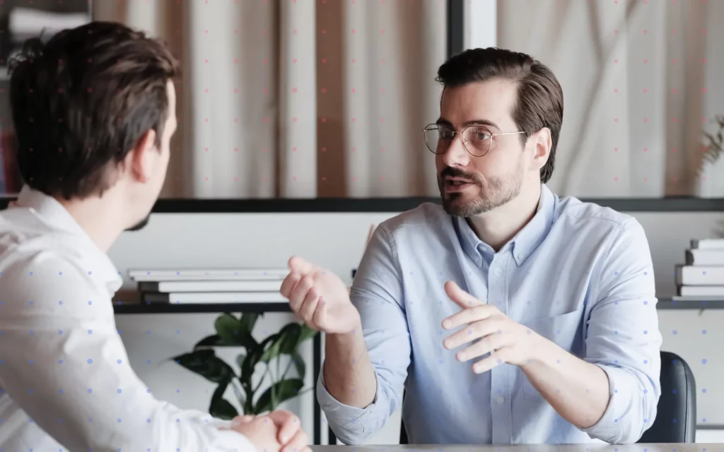 Two people in business attire discuss a project